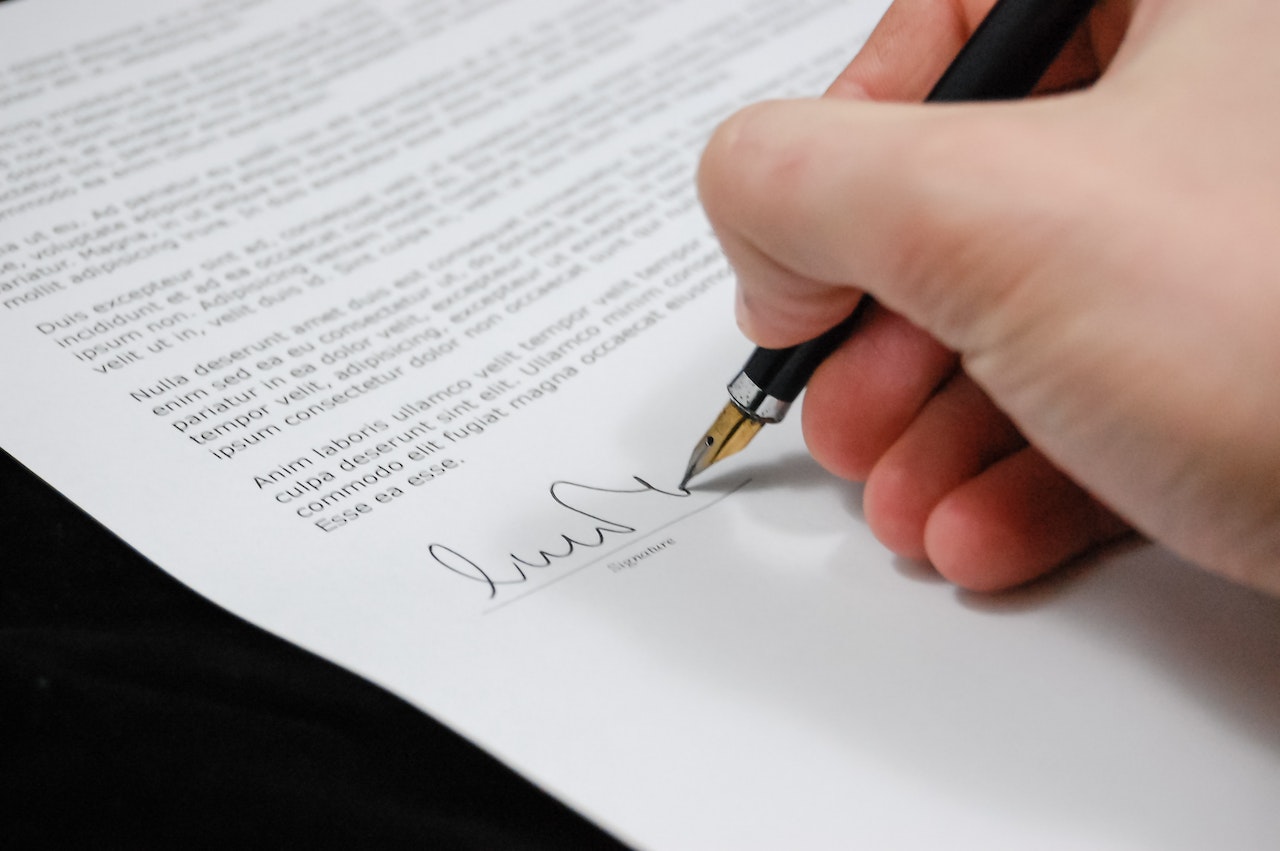 Closeup of  a person signing a legal document